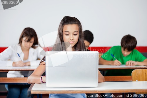 Image of Teenage Schoolgirl Using Laptop At Desk