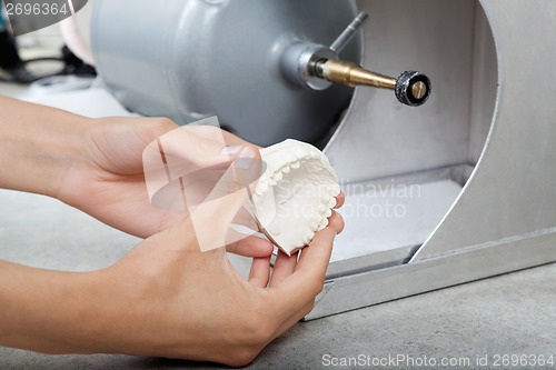 Image of Dentist's Hands Holding Dental Plaster Mold