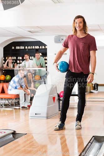 Image of Young Man Holding Ball At Bowling Club