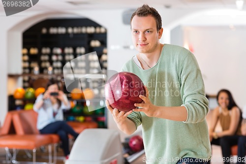 Image of Confident Man Bowling in Club