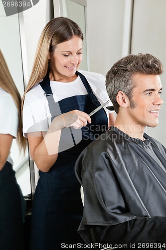 Image of Hairstylist Giving Haircut To Client At Salon