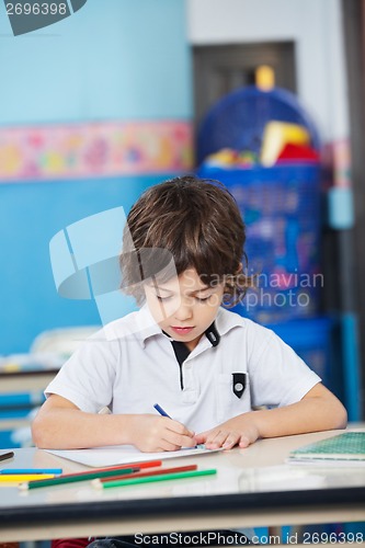 Image of Boy With Sketch Pens Drawing In Kindergarten