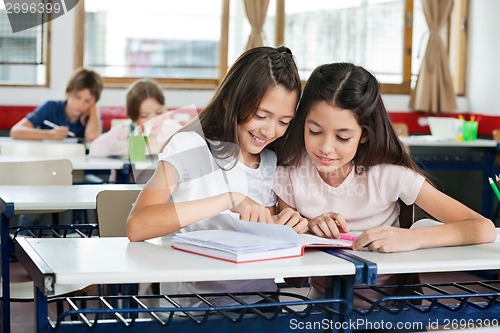 Image of Schoolgirls Studying Together At Desk