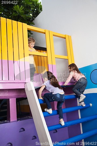 Image of Girls Climbing Playhouse Ladder