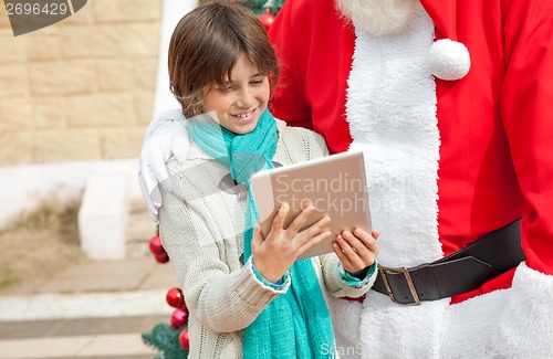 Image of Santa Claus And Boy Using Digital Tablet