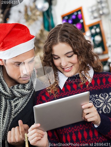 Image of Couple Using Digital Tablet At Christmas Store