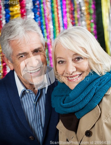 Image of Happy Couple Against Tinsels At Christmas Store