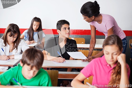 Image of Teacher Assisting Teenage Boy