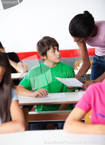 Image of Boy And Teacher Looking At Each Other In Classroom