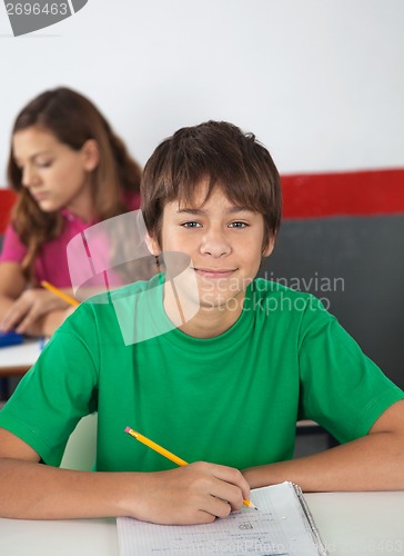 Image of Portrait Of Teenage Male Student Sitting At Desk
