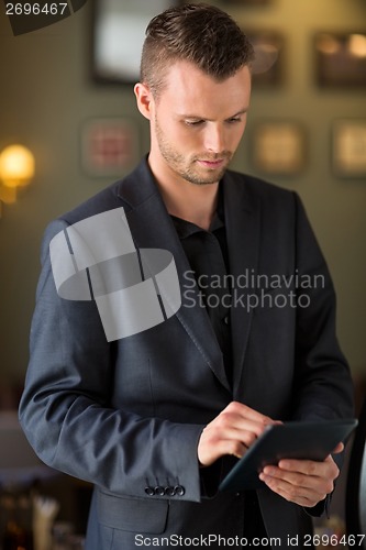 Image of Businessman Using Digital Tablet At Cafe