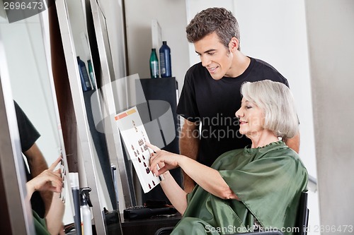 Image of Hairdresser With Customer Selecting Color From Catalogue