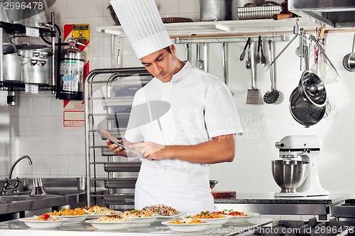 Image of Male Chef Using Digital Tablet In Kitchen