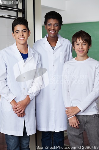 Image of Teacher With Male Students Standing Together In Science Lab