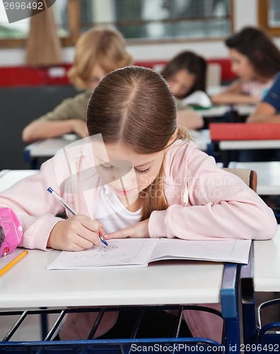 Image of Schoolgirl Writing At Desk