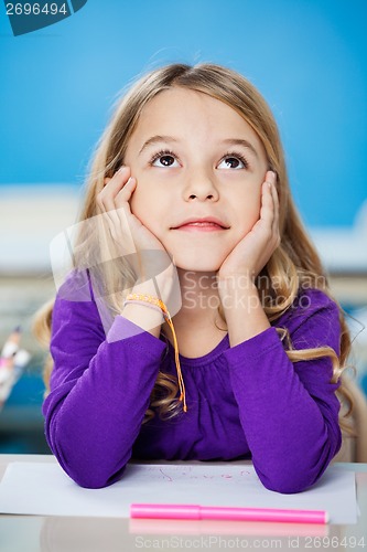 Image of Girl Looking Up While Sitting With Head In Hands In Class