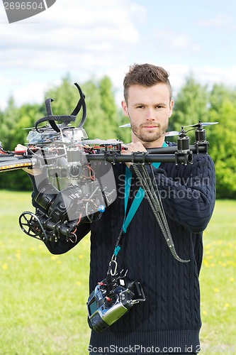 Image of Male Engineer Holding UAV Helicopter in Park