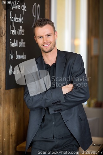 Image of Businessman Standing Arms Crossed In Coffeeshop