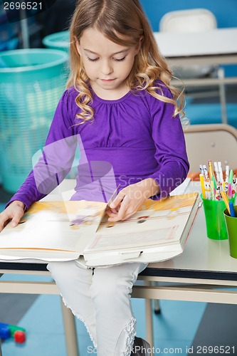 Image of Girl Reading Book In Classroom