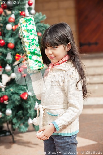 Image of Girl Holding Present In Courtyard