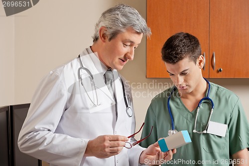 Image of Medical Professionals Looking At Medicine Box