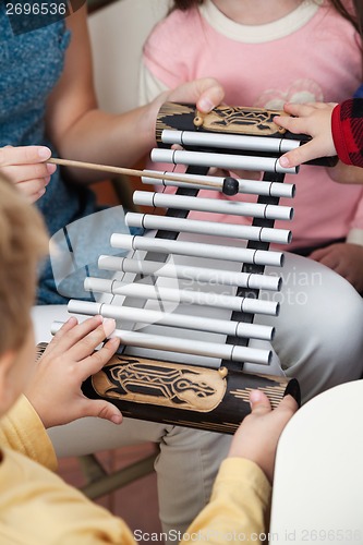 Image of Teacher And Students Playing Xylophone In Class