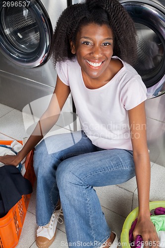 Image of Happy Woman Sitting In Laundry