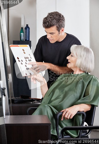 Image of Hairdresser Advising Female Client In Selecting Color