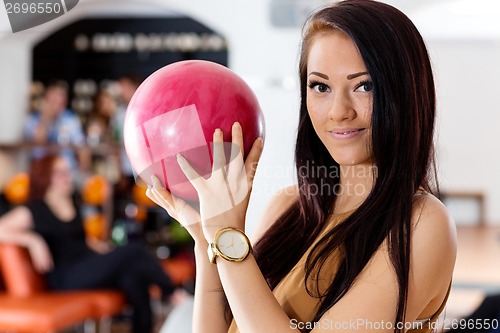 Image of Young Woman Holding Pink Ball in Bowling Club
