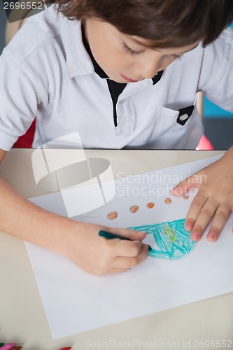 Image of Boy Drawing With Color Pencil In Classroom