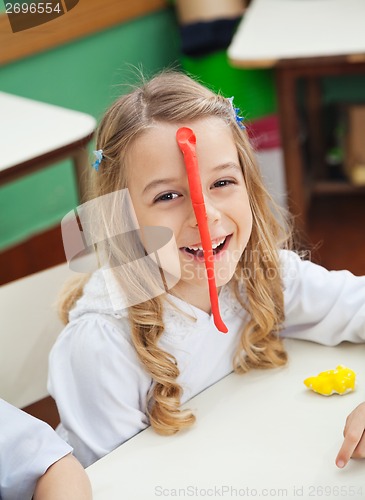 Image of Happy Little Girl With Clay Stuck On Forehead