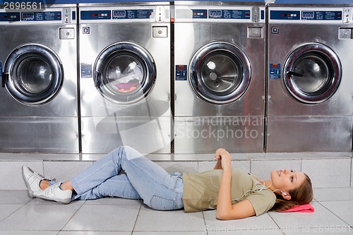 Image of Woman Listening To Music While Lying At Laundry