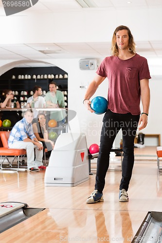 Image of Young Man With Bowling Ball in Club