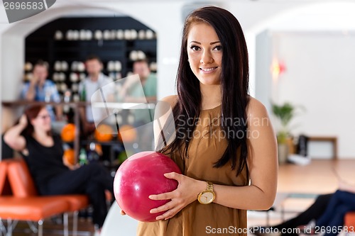 Image of Happy Woman Holding Bowling Ball in Club