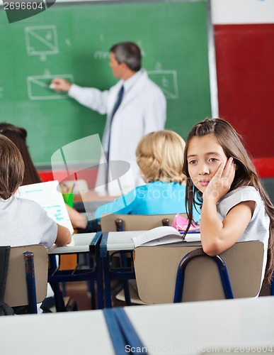 Image of Bored Schoolgirl Sitting In Classroom