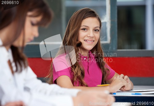 Image of Teenage Schoolgirl Sitting With Female Friend In Foreground