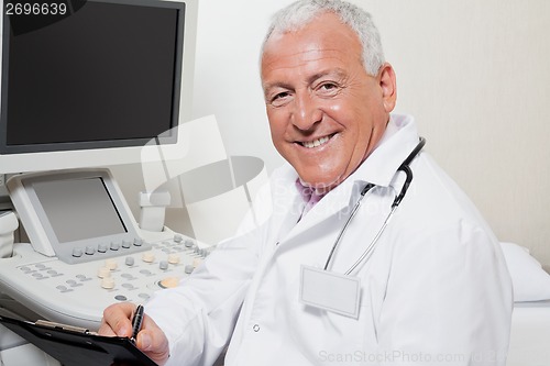 Image of Radiologist Writing On Clipboard