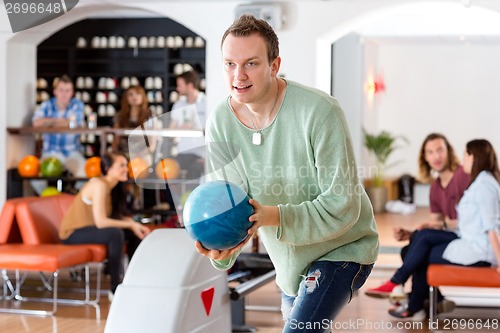 Image of Man Playing in Bowling Alley At Club