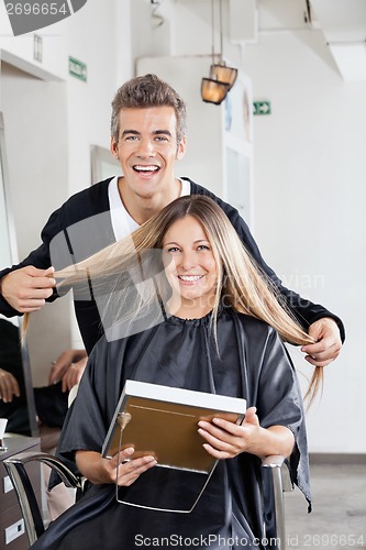 Image of Hairstylist With Client Holding Mirror At Salon