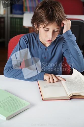 Image of Schoolboy Reading Book At Table