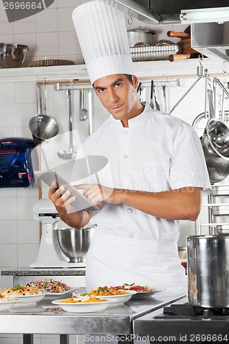 Image of Chef Holding Tablet With Pasta Dishes At Counter