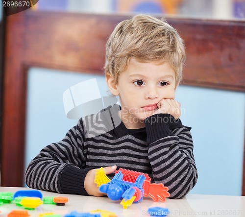 Image of Boy With Blocks Looking Away In Preschool