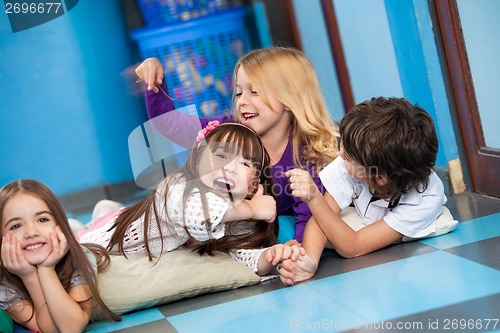 Image of Playful Children Lying On Floor