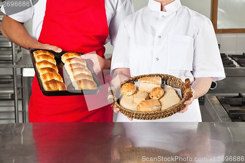 Image of Chefs Holding Baked Breads In kitchen