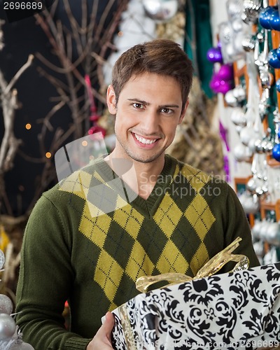 Image of Handsome Man Holding Christmas Gift In Store