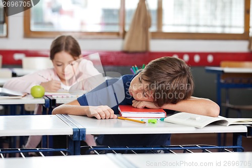 Image of Boy Sleeping On Desk In Classroom