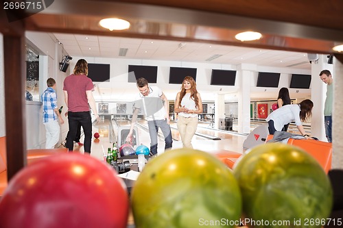 Image of People Bowling With Balls in Foreground