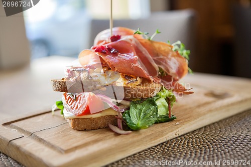 Image of Tasty Parma Ham Sandwich On Wooden Plate