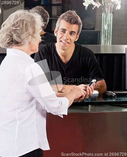 Image of Hairdresser And Client Discussing Over Cellphone