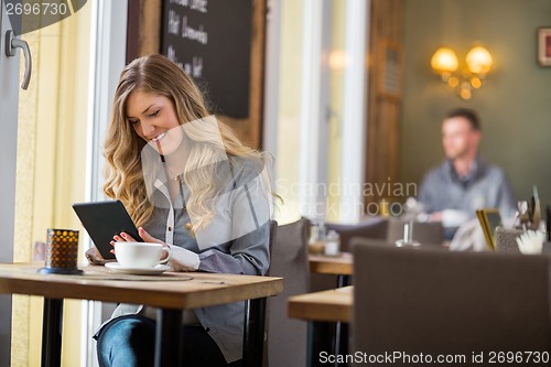 Image of Woman Using Digital Tablet At Table